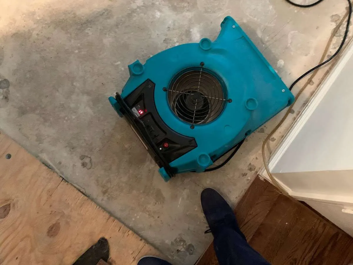 Air mover drying subfloor during Commercial Water Damage Restoration in Kenner